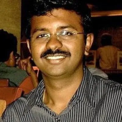 A man in a striped shirt is smiling for the camera.