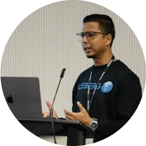 A man standing at a podium with a laptop in front of him.